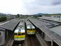 Serie 115 - die Bahn am heiligen Berg Yahikosan: In Yoshida kreuzen sich die beiden Kurszüge der Yahiko-Linie, links Zug 115-501, rechts Zug 115-504. Im Hintergrund die Silhouette des heiligen Yahikosan, Ziel der Yahiko-Linie. 17.Oktober 2011.  