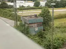 Ein altes kleines Stellwerkim Neusser Güterbahnhof. Es ist schon länger dicht und mit Holz verkleidet und trägt den Namen R1.

Neuss 19.06.2014