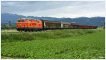 Die Blutorange 2143.035 rollt mit dem Leerzug 63519 (Pöls - Zeltweg) durch das Aichfeld. Im Hintergrund der Förderturm der ehem. Kohlegrube Fohnsdorf.  
17_6_2014