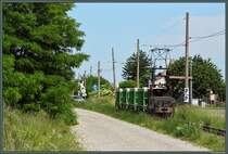 Mit einem Kalksteinzug rollt Lok 2 der Werkbahn des Sodawerkes Staßfurt über den Bahnübergang Richtung Werk. Die 600mm-Feldbahn ist eine der wenigen noch in Betrieb befindlichen elektrifizierten Werkbahnen Deutschlands und wird auch am Wochenende rege genutzt. (31.05.2014)