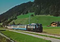MOB: Zementverkehr Montreux-Saanen im Juli 2003. Die Zufuhren der beladenen Zementwagen ab Montreux sowie die Abfuhren des Leermaterials ab dem Bahnhof Saanen wurden jeweils den Regionalzügen mitgegeben. Das Rangiermanöver um Saanen wurde mit einem alten in Saanen stationierten Triebwagen abgewickelt. Regionalzug mit Ge 4/4 8001-8004 kurz vor Saanen.
Foto: Walter Ruetsch