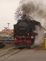 99 749 der S�chs.-Oberlausitz-Eisenbahn zuckelt mit ihrem Regelzug am Mittag des 23.12.2006 von Zittau durch die gleichnamige Stadt in Richtung Bertsdorf.
Die Konstruktion im Hintergrund d�rfte wohl ziemlich einmalig sein: Bahn�bergang auf einer alten Stahlbr�cke.