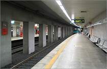 Grautöne herrschen vor -

Willy-Brandt-Platz, 1975, Linien U4 und U5. Einer der schönsten Untergrundbahnhöfen Deutschland befindet sich im vierten Untergeschoß unter dem Frankfurter Willy-Brandt-Platz. Die Farbgestaltung ist sehr zurückhaltenden in feinem Grau. Den kräftigen Mittelstützen sieht man deutlich ihre Aufgabe, die darüber befindlichen Lasten zu tragen, an. Die Wände sind passendend dazu mit einer Art Waschbetonplatten verkleidet, ein Material, das heute viel zu selten eingesetzt wird. In diesem Bahnhofsteil fahren die Linien U4 und U5, während ein Stockwerk höher die Linien U1, U2 und U3 kreuzen.  

12.02.2005 (M)