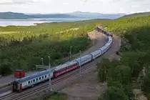 Zugkreuzung am Bf Torne Träsk,während der Ic 96 von Narvik nach Stockholm wartet wird er gekreuzt von einem vollen Erzzug der in Richtung Narvik unterwegs ist,geführt von den Doppelerzloks Björkliden 110 und Lulea 103.Bild vom 20.7.2014
