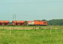Bei Beckrath kommt eine unbekannte V100 Ost von Swietelsky mit einem Schotterzug von der Baustelle hinter Erkelenz nach Rheydt Rangierbahnhof gefahren, wo sie im Güterbahnhof ihren momentanen Stützpunkt hat. 28.9.2014