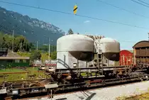 Silowagen Ucs der SBB aufgeschemelt auf dem Ua9848 der Brünigbahn in Interlaken-Ost, August 1993 [Staubbehälterwagen, Staubgutwagen]