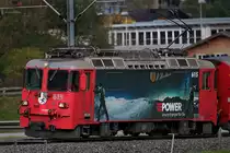 Die SLM Lok Ge 4/4 II 617  Klosters  der Rhb mit der Werbung für Re Power mit einem RE nach Landquart bei der Durchfahrt in Schiers.Bild vom 20.10.2014