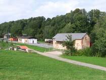Gesamtansicht Bahnhof Lohsdorf: Im Vordergrund der alte G�terschuppen, in der Gleisachse die zum Abriss stehende LPG-Halle und links das Bahnsteiggleis mit dem wiedererrichteten Empfangsgeb�ude
