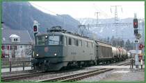 Eine Ae 6/6 f�hrt mit G�terlast aus dem Anschlussgleis der Ems Chemie auf das Dreischienengleis in Domat/Ems. Bis Chur ben�tzt der Normalspurzug das rechte Gleis, denn nur dieses ist mit einer dritten Schiene ausgestattet. (11.01.2007)