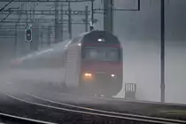 Re 460 085-4 braust mit einem IC von Chur nach Zürich HB bei Bodennebel in Weesen vorüber.Der rechte Scheinwerfer dürfte da mal ersetzt werden...Bild vom 14.11.2014