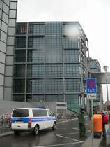 Blick von der Minna-Cauer-Stra�e (neue Stra�en im Mitte erhalten nur weibliche Namen, bis ein Verh�ltnis von 50:50 herrscht) auf die defekte Fassade des Hauptbahnhofs. Am 18.1.2007 war hier in der Nacht bei starkem Sturm ein 2 Tonnen schwerer Tr�ger auf die Treppe gest�rzt. Verletzt wurde niemand. Der Fassadenteil ist ein Schmuckelement, nach Zeitungsberichten liegen diese im Ger�st, sind aber nicht gesondert befestigt. Die Bundespolizei sperrt seither die gef�hrlichen Bereiche ab. Die Minna-Cauer-Stra�e kann gar nicht, das Friedrich-List-Ufer nur von BVG-Bussen (diese sind wohl weniger gef�hrdet) befahren werden. 21.1.2007