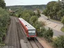 „Nachschuss“ von der Brücke über die Bahnsteige in Weikersheim am 20.8.14: Der mit Zusatzlampen ausgestattete 628 234 schiebt seinen Steuerwagen nach Würzburg weiter. Der in den 1990er Jahren erbaute Busbahnhof dient auch zahlreichen Schul¬bussen, da auf der Höhe auf der anderen Fußgängerbrücke das Gymnasium liegt.