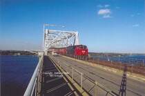 Rckkehr an die Kleinbeltsbrcke (Gammel Lillebeltsbro), ca. 1991, als noch kein Fahrdraht nach Fyn ging. Eine MZ zieht eine schne Garnitur ber die Meerenge. Das Wetter ist traumhaft. Vom Wind 35 Meter ber dem Meer sieht man auf dem Bild nichts....Noch heute komme ich jedesmal wieder hier hin. Rechts wieder die neue Bro mit dem Motorvej (Autobahn). Weitere alte Bilder von der schnen Brcke sind gerne gesehen. Wer hat etwas? Wrde gerne mal was schreiben ber diese tolle Brcke!

