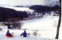 Nebenbahn Hof - Bad Steben im Winter. Ein 614 fhrt Richtung Hof gerade in die Steigung bei Rothenbrg ein. Die Buben haben Spa beim Rodeln. Aufnahme vom 14.02.1988. Beim jngsten Sturm Kyrill wurde der Wald links vom Tw komplett umgelegt...
Es handelt sich um ein Bild nach dem Motto  Eisenbahn in der Landschaft . Oder aber auch Ansichten von der KBS 857...nur falls das jemand nicht bemerkt hat. Wenn man einen 614 aus der Nhe oder ein evtl. zuflliges Detail davon sehen will, muss man andere Bilder ansehen. Dieses hier hat aber gewissen Anspruch.
Abdruckgenehmigung ggf. bei mir.

