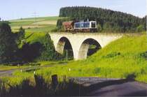 08.06.1983. Die 211 302 vom Bw Hof bringt einen Wagen nach Schauenstein an der ehem. Linie Helmbrechts - Selbitz, die 6 Jahre vorher zwischen Schauenstein und Selbitz abgebaut worden war. Heute liegen hier keine Gleise mehr, der Abbau erfolgte auch noch 211ern. Die Brcke steht heute als Relikt ohne Funktion herum.
Abdruckerlaubnis ggf. bei mir erhltlich.