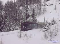 Ge 4/4 II mit Reisezug hat gerade talw�rts den Toua-Kehrtunnel, er liegt unter dem Zwondra-Kehrtunnel, verlassen - M�rz 1979. Auf diesen Abschnitt wird der gr��te H�henunterschied �berwunden, von Berg�n bis Preda 416 Meter, Maximalsteigung 35 Promille.