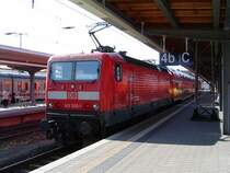 BR143 305 wartet hier mit ihrer RB nach Rostock im Stralsunder Hbf. (12.06.03)