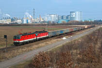 1144 048 und 1144 270, unterwegs vor der Kulisse der Zuckerfabrik in Tulln, in Richtung St. Pölten. Die Aufnahme entstand am 15.02.2015.