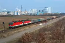 1144 048 und 1144 270, unterwegs vor der Kulisse der Zuckerfabrik in Tulln, in Richtung St. Pölten. Die Aufnahme entstand am 15.02.2015.