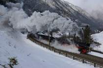 Bei sehr starkem Wind befördern die Pacific 01 202 und 01 1066 einen Extrazug die Gotthard-Nordrampe hinauf. Am Zugschluss half die Ae 6/6 11407 mit. Bild aufgenommen in der Wattinger-Kurve bei Wassen am 05.03.2015.