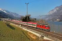 Re 4/4 II 11129 mit dem EC von Zürich HB nach Graz braust bei Unterterzen vorüber.Bild vom 12.3.2015