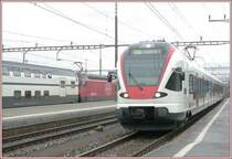 Flirt 523 006-5 f�hrt in Rotkreuz ein und ein IC2000 zum Z�rcher Flughafen f�hrt aus. (12.02.2007)
