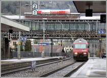 Eine Re 460 f�hrt in den Bahnhof Arth-Goldau ein, w�hrenddem dar�ber in der Passarelle der Triebwagen Nr. 14 der Rigibahnen auf Fahrg�ste wartet. Wegen des Regenwetters sind wir allerdings nur zu dritt. (12.02.2007)