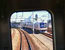 Seibu Konzern / Tôkyû Konzern: Bei der Einfahrt in die Station Tokyo-Fujimidai begegnet ein Gegenzug in Form einer Komposition des Tôkyû-Konzerns (Zug Tôkyû 5174). Dieser Zug ist vom chinesischen Viertel in der Stadt Yokohama her nach Tokyo gekommen; als U-Bahn Kurszug der Fukutoshin-Linie hat er dann das Netz des Seibu-Konzerns erreicht, wo er nun Nordwesten hinaus fährt. 14.Oktober 2014.  