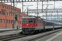 Re 4/4 II 11128 durchfährt den Bahnhof Muttenz. Die Aufnahme stammt vom 22.06.2015.