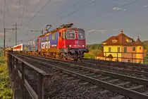 Im allerletzten Büchsenlicht fährt die Re 421 371-6 mit dem EN von Zürich HB nach Prag in Keuzung eines Güterzuges beim Pumpwerk Löli in Kaiseraugst vorüber.Bild vom 26.6.2015