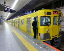 Seibu-Konzern, Endstation Hon-Kawagoe: Zehnwagenzug, bestehend aus einem Vier- und dem Sechswagenzug 2031 (Serie 2000). Der Schaffner am Zugsende studiert im Fernsehen das Geschehen (bzw. das Nichts-geschehen) am Bahnsteig. 29.Oktober 2013. Die Serie 2000 wurde in Varianten 1977-1992 gebaut, teilweise noch in der Seibu-Fabrik selbst. 2017 waren noch 372 Wagen vorhanden; einige wenige sind ausgemustert.  