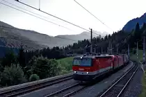 1144 048 und 1116 xxxx fahren in der Dämmerung mit einem gemischten Güterzug den Arlberg hinauf.Bild Wald A/a vom 22.7.2015
