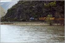Eine MWB 212 f�hrt mit einem Bauzug im April 2006 am Rhein entlang und durchf�hrt gleich den Bahnhof von Kestert.