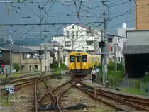 Serie 105 im Hinterland von Fukuyama: Die Stadt Fukuyama liegt in der Präfektur Hiroshima an der Inlandsee weit im Westen von Japan; dreitürige elektrische Züge Serie 105 fahren bis an die Berge heran, dann geht es mit dem Schienenbus hinauf ins Hochland. Im Bild rangiert Zug 105-3 am Ende der elektrischen Strecke in Fuchû, während sich im Hintergrund ein Gewitter aufbaut. 13.August 2013.   