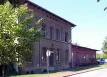 Ehemaliger Bahnhof Havelberg: Weitere Ansicht von der Straßenseite, die hier auch den angebauten Güterschuppen zeigt. Im ganzen ist das Gebäude recht gut erhalten, keine Zeichen von Vandalismus. Die ehemalige  Gleisseite ist  abgezäunt und als Bootslagerplatz benutzt, daher kaum zugänglich. 22.8.2015