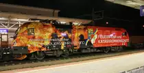 Die 1016 048-1  Niederösterreichischer Landesfeuerwehrverband  der ÖBB hält in der Nacht des 16.9.2015 mit einem Güterzug von Hall in Tirol nach Wels im Bahnhof Wörgl. Der Zug bekommt 2 Vorspannlok´s, eine 1144 und 1216 für die Fahrt über die Giselabahn(Kitzbühel)nach Oberösterreich.