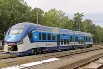 Am 15.09.2015 wartet 844 008 in Domažlice auf seinen nächsten Einsatz als Os nach Plzeň. Die in Polen gebauten RegioSharks sind eine interessante Bereicherung des tschechischen Fahrzeugparks. Auch der Fahrkomfort und die Ausstattung können überzeugen, die Triebzüge werden ja nur im Nahverkehr verwendet. Ein bemerkenswertes Detail sind die seitlichen Fensterscheiben, die nicht senkrecht eingebaut sind. Deren oberes Ende ist etwas weiter außen als das untere Ende, den Effekt sieht man, wenn es regnet, man hat (fast) immer klare Sicht nach draußen. 