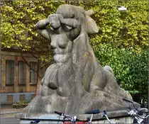 Zeitgenössische Kunst am Bau vor dem badischen Bahnhof in Basel. Als Ensemble stehen sich zwei Brunnen gegenüber, die gegenwärtig als Blumentöpfe missbraucht werden. Dieser Brunnen symbolisiert die Wiese, angeschoben von einem Stier. Die Wiese fliesst in Basel in den Rhein. September 2015.