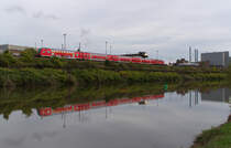 Der RE Saarbrücken - Koblenz hat den Bahnhof Völklingen verlassen und passiert das Brammenlager der Saarstahl AG. Direkt zwischen Saar und Werksgelände verläuft die Bahnstrecke 3230 Saarbrücken - Karthaus. 21.10.2013