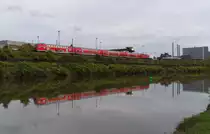 Der RE Saarbrücken - Koblenz hat den Bahnhof Völklingen verlassen und passiert das Brammenlager der Saarstahl AG. Direkt zwischen Saar und Werksgelände verläuft die Bahnstrecke 3230 Saarbrücken - Karthaus. 21.10.2013