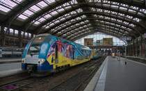 Auch der SNCF Z24655/24656 (Rame 378) vom Typ TER 2N-NG (2 Niveaux-Nouvelle Génération = Doppelstock-Neue Generation) der Region Nord-Pas-de-Calais trägt eine Werbung.
Oben auf dem Triebkopf sieht man, dass dies der 100.Triebzug des Typs TER 2N-NG ist.
Dieser Triebzug wurde im in der Region Nord-Pas-de-Calais gelegenen Alstom-Werk in Valenciennes hergestellt und mit einer entsprechenden Werbung versehen.
2014-07-21 Lille-Flandres