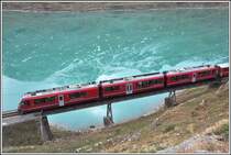 R1633 mit ABe 8/12 3508 auf der Brücke am See unmittelbar hinter der Station Ospizio Bernina auf 2253m ü/M.. Im Lago Bianco spiegelt sich an diesem Morgen der Cambrenagletscher. (08.10.2015)