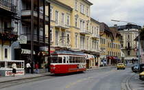Nur 2,3 km sind es von der Endhaltstelle am Franz-Josefs-Platz bis zum Bahnhof, damit gilt die Gmundner Straßenbahn als kleinste der Welt. Hier wartet GM 9 im August 1987 auf Fahrgäste. Obwohl es sich bei den Triebwagen um Zweirichtungsfahrzeuge handelt, wurden die Türen auf einer Seite entfernt, da die Haltestellen alle auf der gleichen Seite liegen.