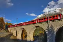 Ge 4/4 II 614  Schiers  fährt mit einem Re nach Scuol über die Chapellabrücke über den Bach Vallember.Bild S-Chanf vom 19.10.2015