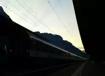 Dämmerung im Bahnhof Erstfeld. Hier verlassen soeben Re 460 081-3 und Re 460 031-8 am 21.7.2015 mit IR 2438 (Locarno - Zürich HB) den Bahnhof.