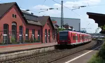 425 135 hat einen Planhalt im Bahnhof Völklingen. Im Vordergrund das alte Empfangsgebäude, heute ein Restaurant und Schulungsraum der VHS Völklingen. Gleich wird der Triebwagen mit dem Ziel Saarhölzbach den Völklinger Bahnhof verlassen. Bahnstrecke 3230 Saarbrücken - Karthaus am 12.07.2013