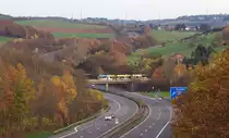 Auf der Suche nach neuen Motiven waren wir am 08.11.2015 im Heusweiler Ortsteil Hirtel unterwegs. Von der Feldwegbrücke über die Autobahn 8 hat man einen Blick auf die Köllertalbahn, heute die Trasse der Saarbahn zwischen Heusweiler und Lebach.
Mit ein paar Minuten Verspätung rollt ein Saarbahntriebwagen über die A8 in Richtung Heusweiler. Bahnstrecke 3291 Lebach - Völklingen. 