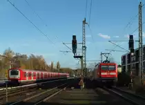 Während ein HVV Triebzug BR472 auf den nächsten Einsatz als S21 wartet, schiebt 112 105-2 den RE1 nach Rostock; Hamburg-Bergedorf, 09.11.2015
