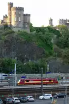 Eine Class 90 (90020) abgestellt im Bahnhof Edinburgh-Waverly als  standby -Lok. Die Lok trägt noch das Farbschema der EWS, gehört jedoch zur DB Schenker Rail (UK) Ltd. Im Hintergrund Governors House auf dem Calton Hill. Der Bahnhof liegt in einem durch Gletscherwanderung enstandenen engen Tal nördlich der Altstadt von Edinburgh, was hier gut sichtbar ist (30.08.2014).
