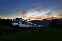 Nachschuss bei einem schönen Morgenrot in den Voralpen fährt der Voralpenexpress Triebzug RBDe 561 084 in Kaltbrunn vorüber.Bild vom 11.11.2015